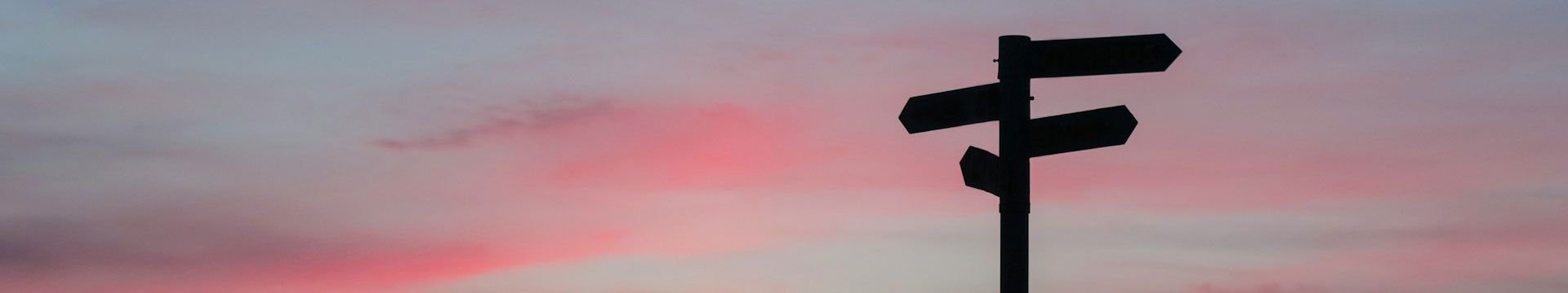 directional sign in silhouette at sunset symbolizing a potential career pivot for a job seeker