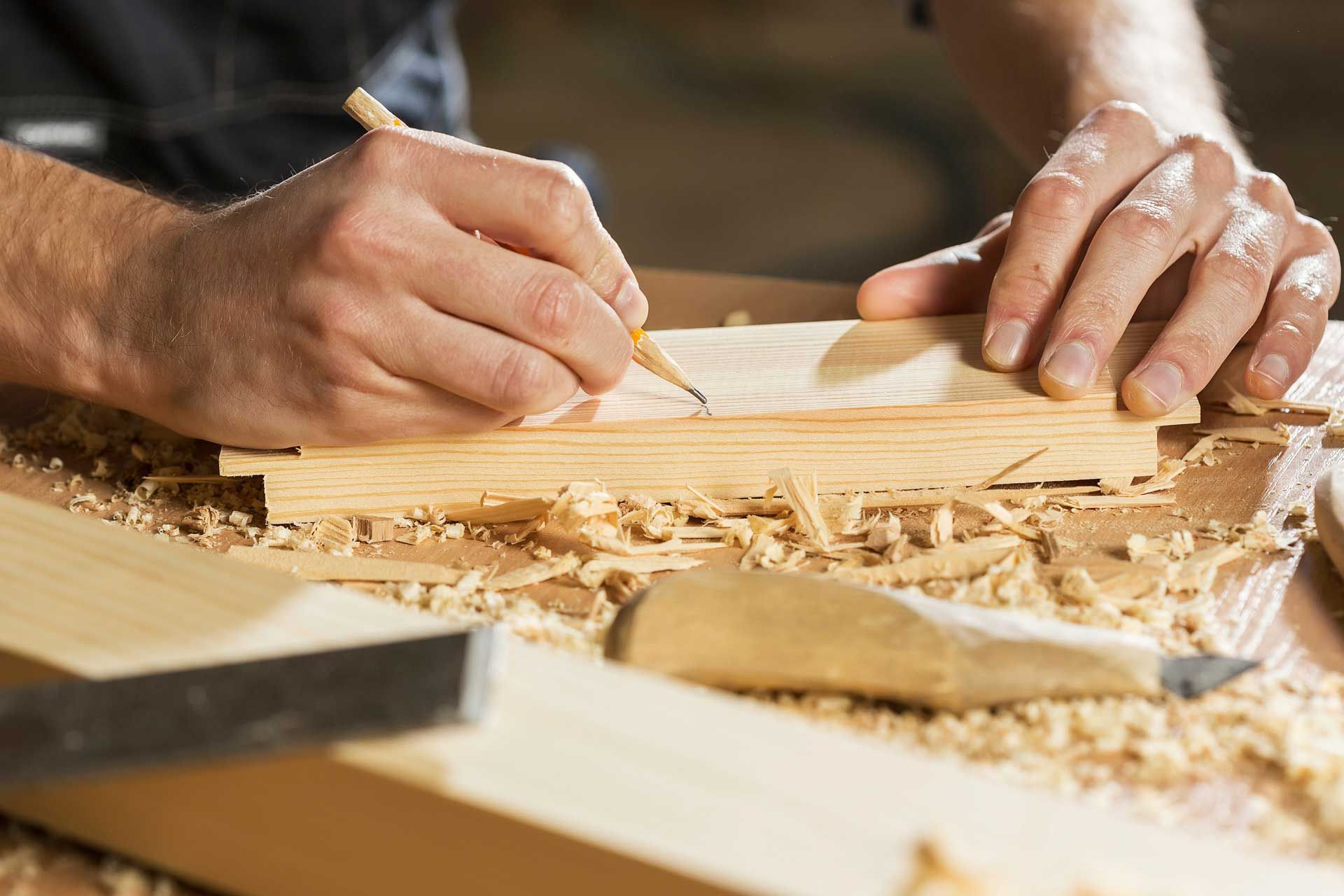 Professional working on a personal creative woodworking project at a table during a job search