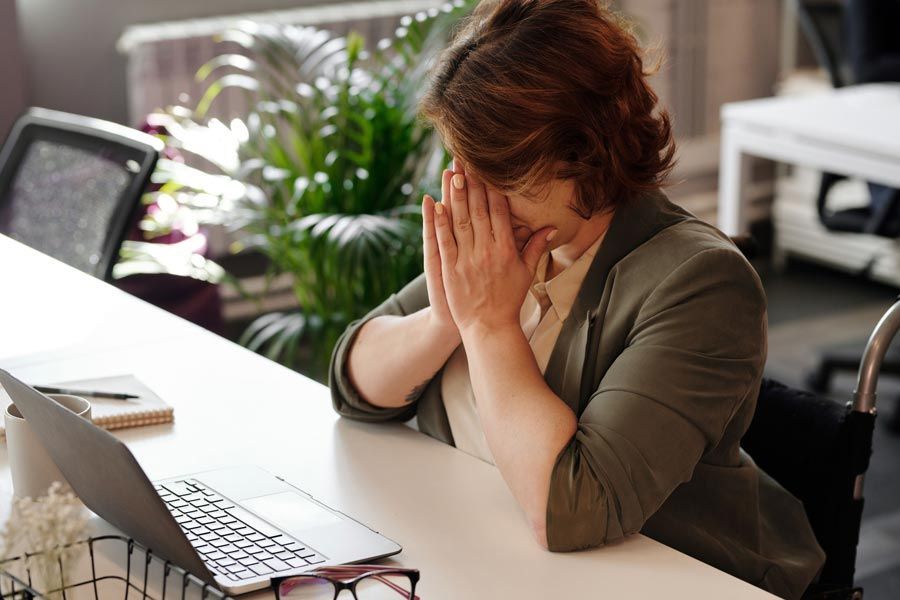 Frustrated executive business woman sitting at a computer while searching for a new job.