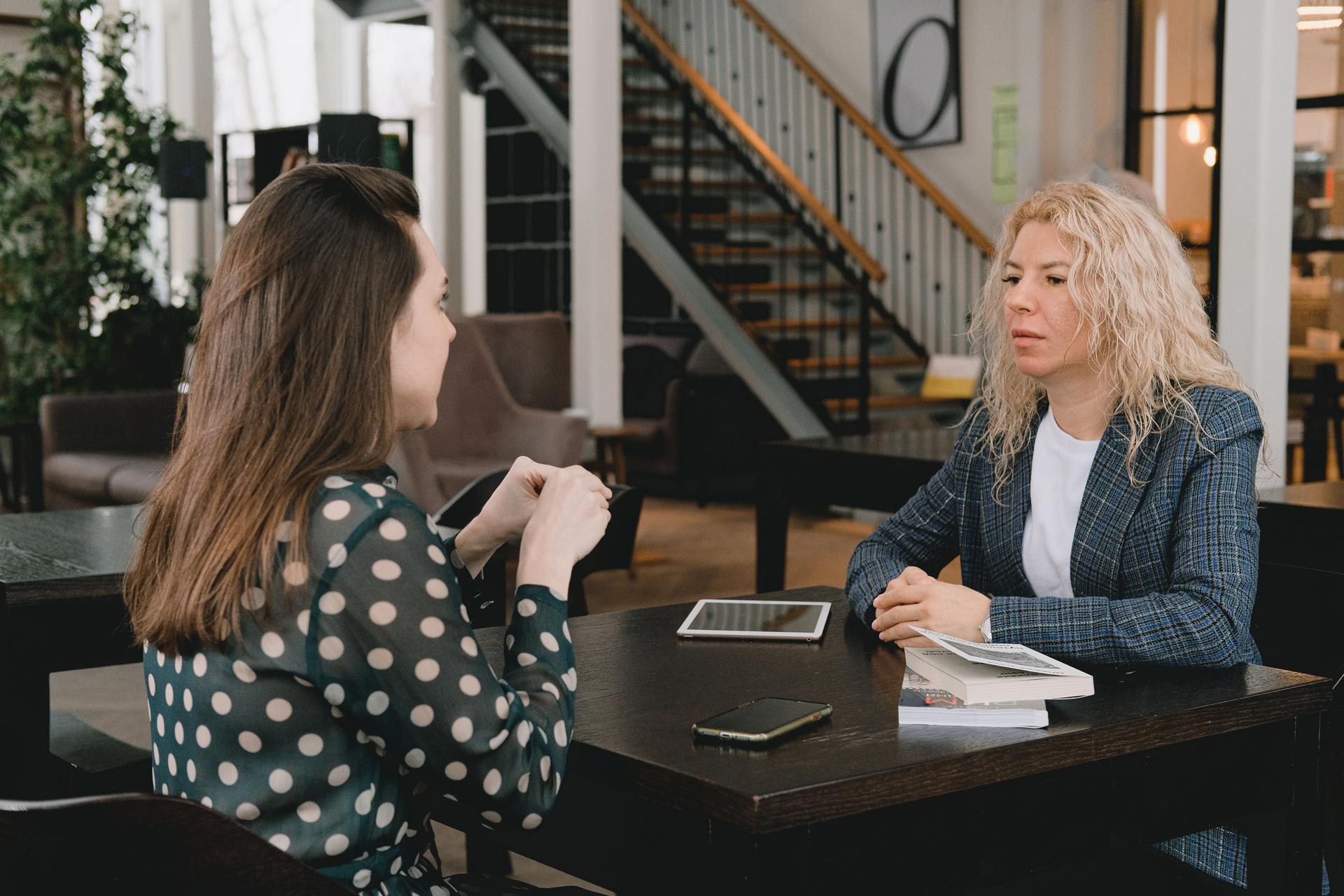 Two women, one an executive recruiter, discussing career opportunities in a professional setting.