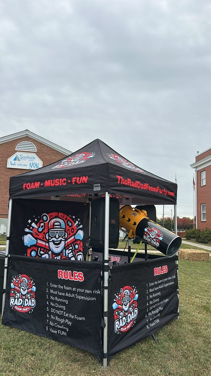 Black food concession tent with skull graphics and red lettering in a parking lot under cloudy skies