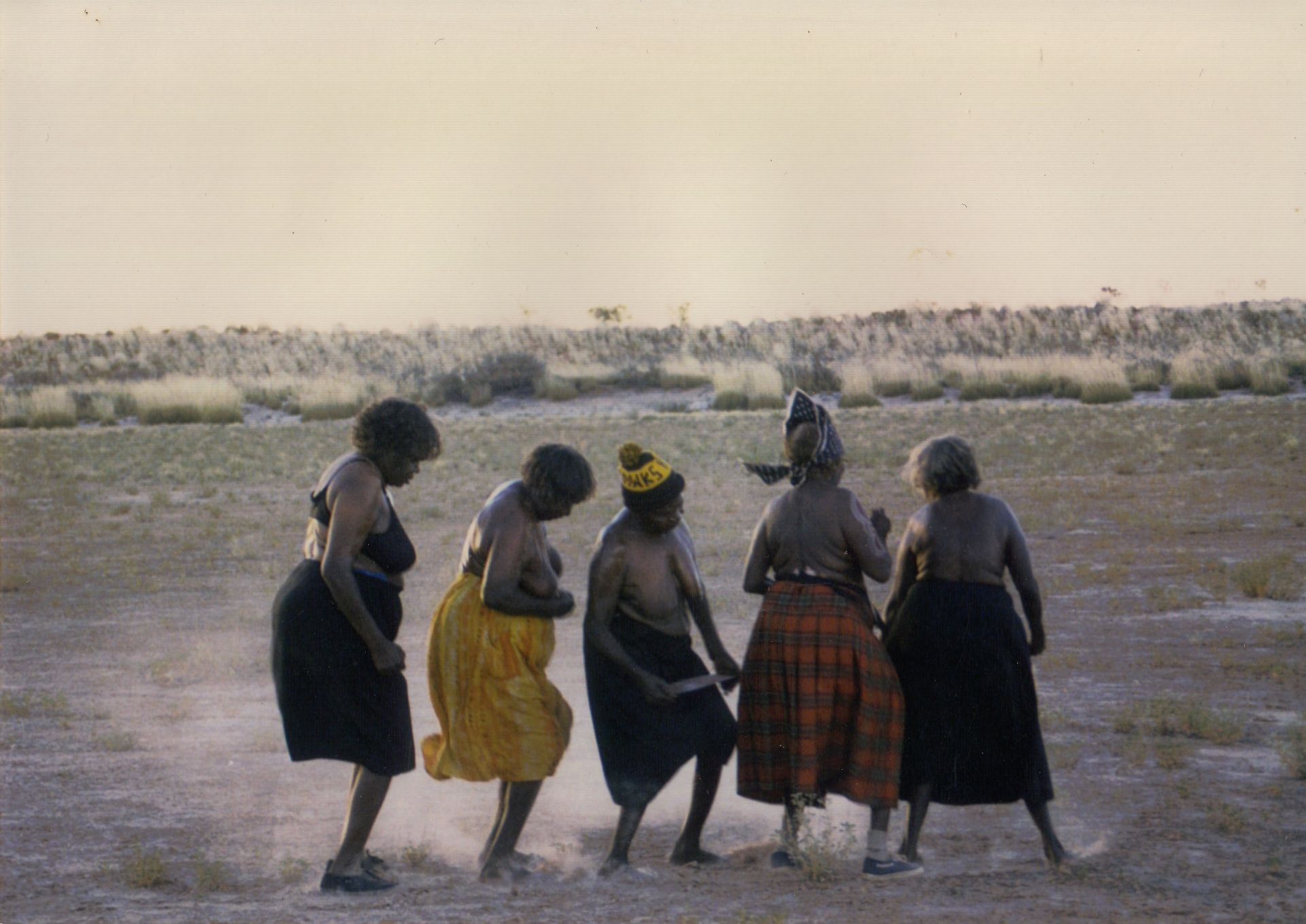 A group of women are dancing in a field