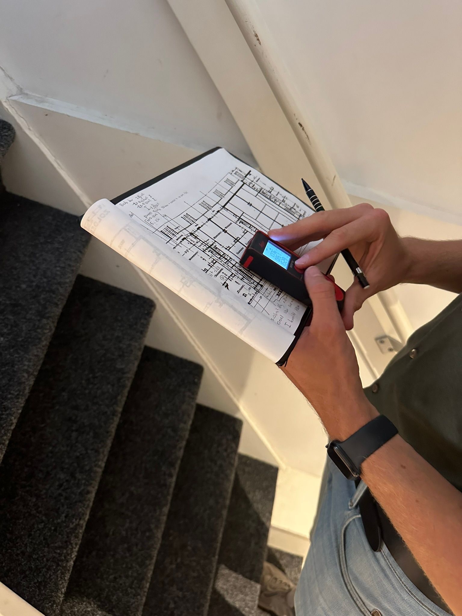 adviseur houd tekening van woning vast en een meting van de laser 