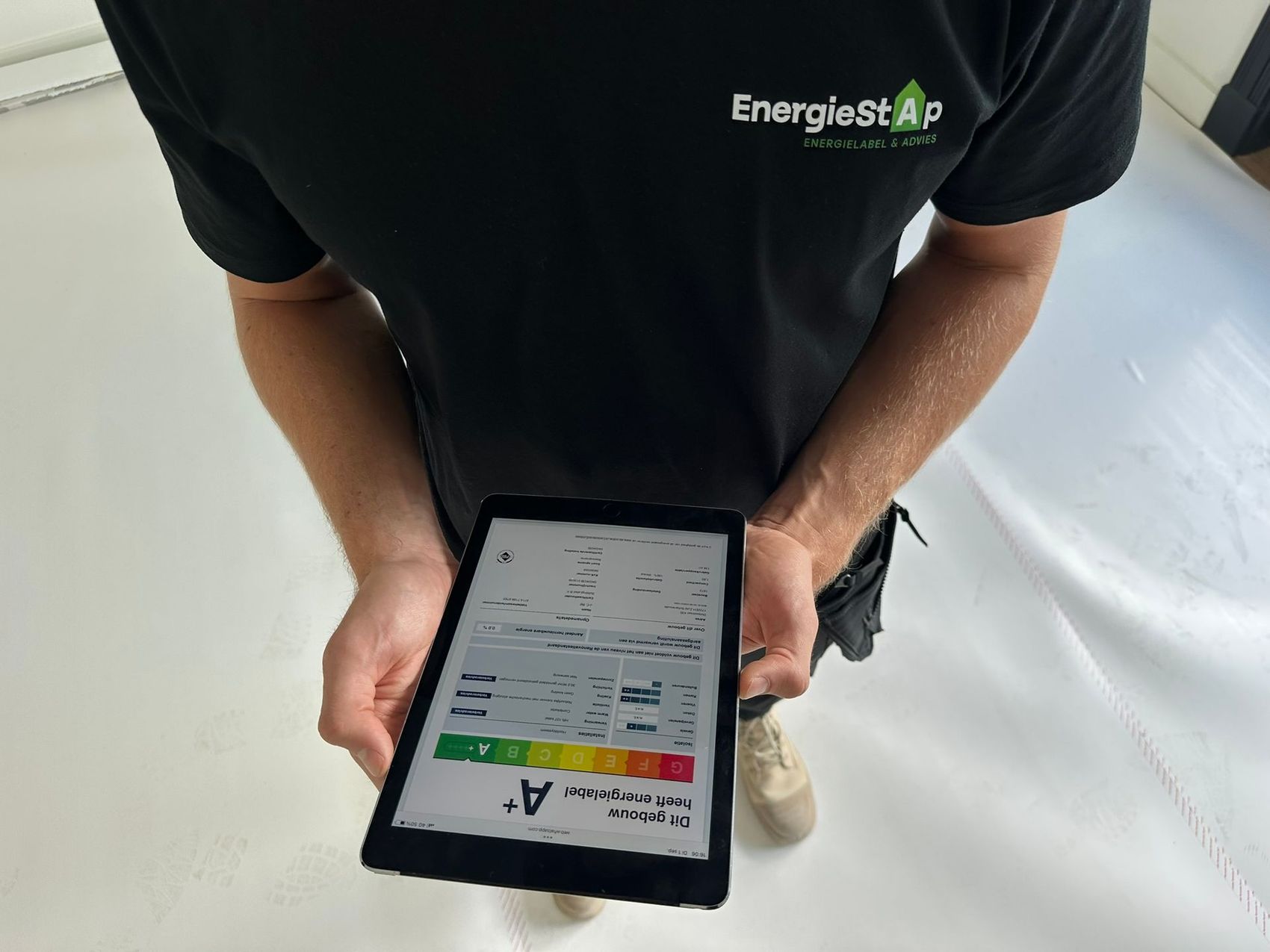 adviseur houd ipad vast met energielabel er op 