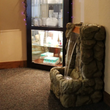 Indoor hallway with a faux-stone water fountain beside a glass display cabinet