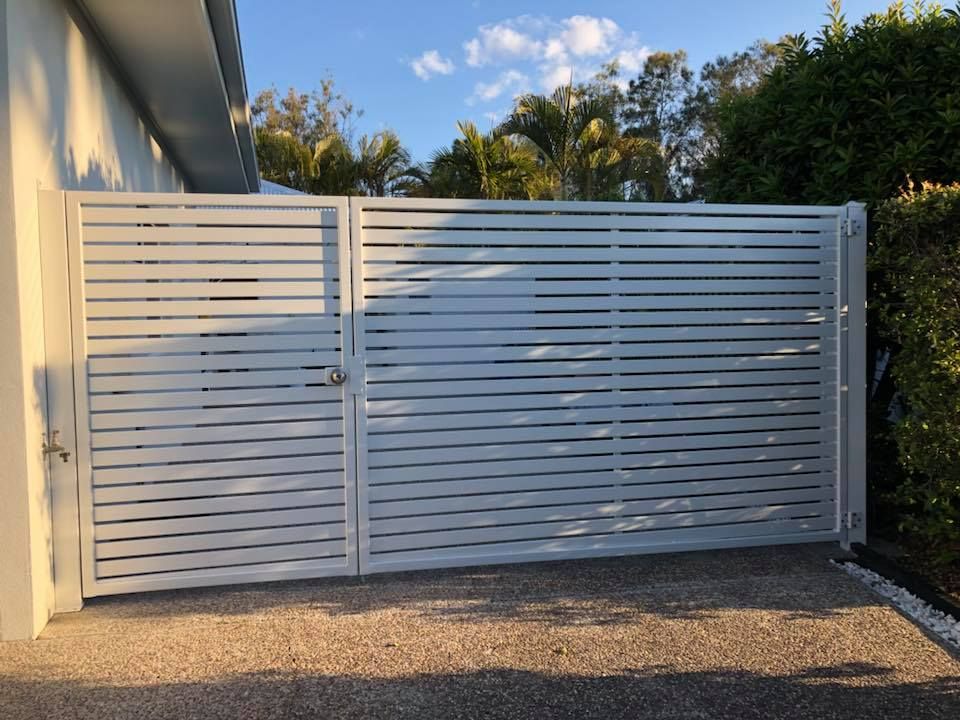 White horizontal slat fence with gate, driveway, and house — Sunshine Gates in Caloundra, QLD