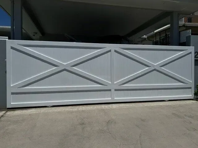 A White Gate With Crosses on It is Sitting in Front of a Building — Sunshine Gates in Kunda Park, QLD