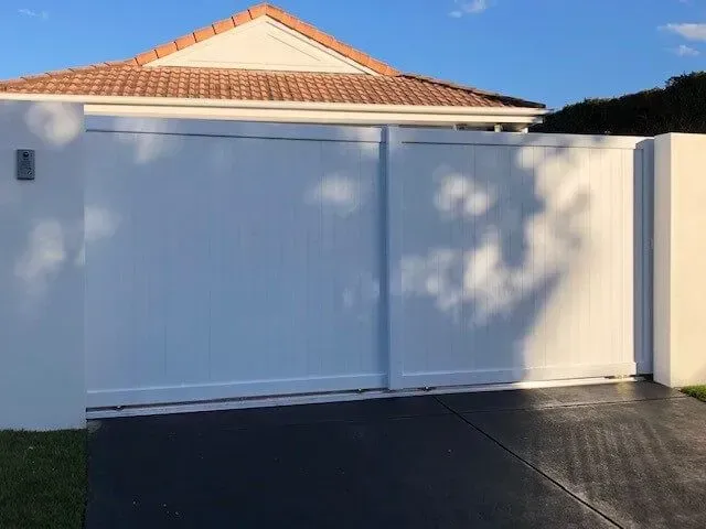 A White House With a Sliding Gate in Front of It — Sunshine Gates in Kunda Park, QLD