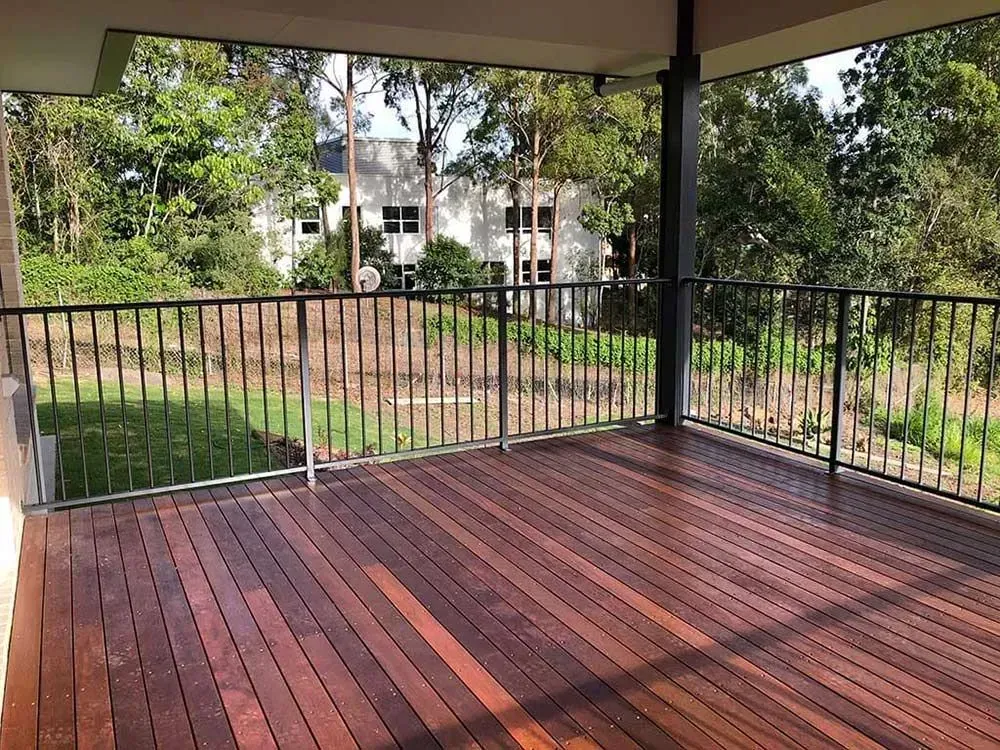 An Empty Wooden Deck With a Metal Railing and a View of a House — Sunshine Gates in Kunda Park, QLD