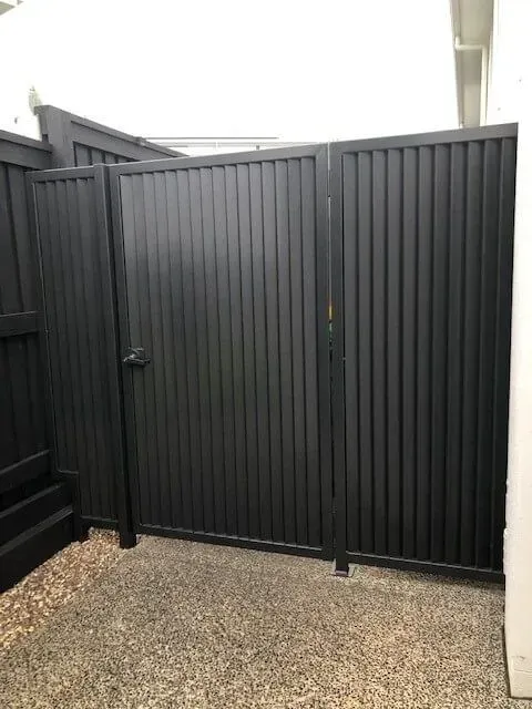 A Black Fence With a Gate in the Backyard of a House — Sunshine Gates in Kunda Park, QLD