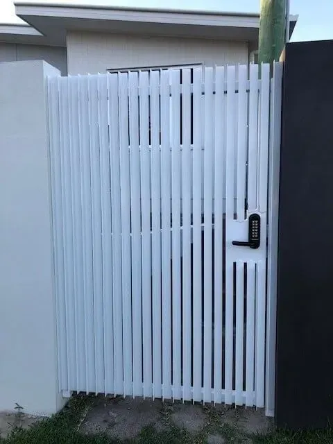 A White Gate With a Black Handle is Sitting in Front of a House — Sunshine Gates in Kunda Park, QLD