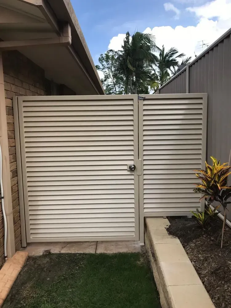A White Gate With Shutters on It is in Front of a House — Sunshine Gates in Kunda Park, QLD