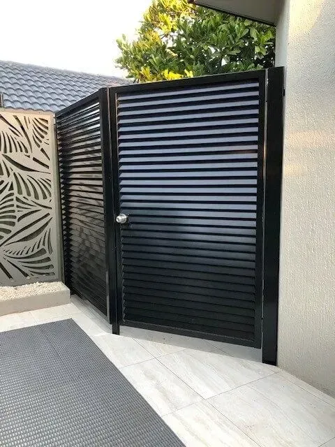 A Black Gate With Shutters on It is Sitting Next to a Wall — Sunshine Gates in Kunda Park, QLD