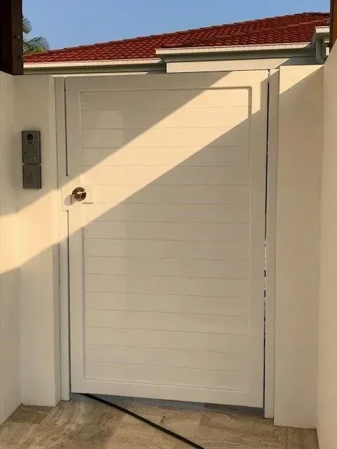 A White Door With a Red Roof is Sitting Next to a White Wall — Sunshine Gates in Kunda Park, QLD