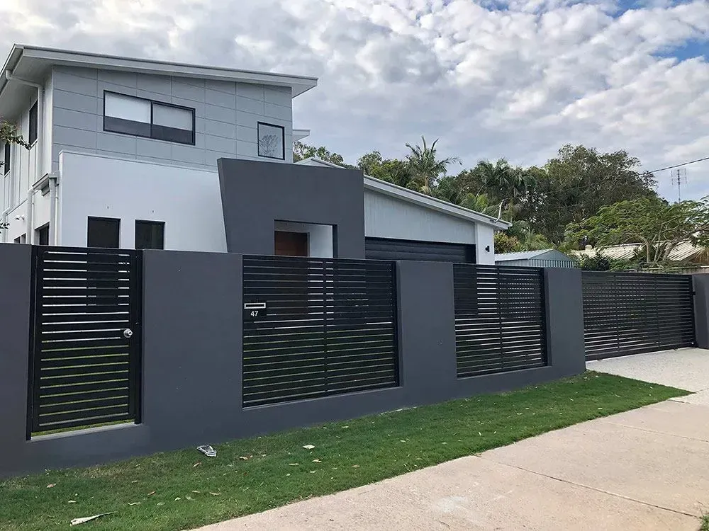 A White House With a Black Fence in Front of It — Sunshine Gates in Kunda Park, QLD