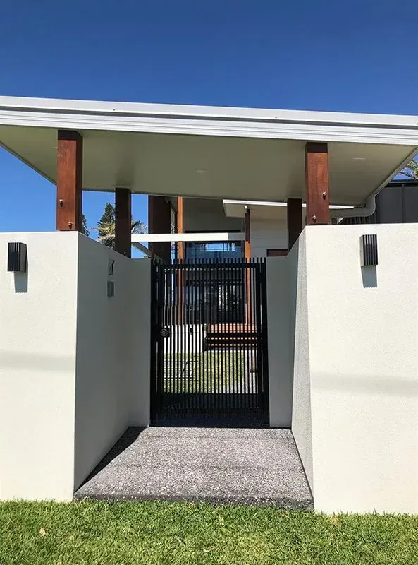 A White House With a Black Gate in Front of It — Sunshine Gates in Kunda Park, QLD