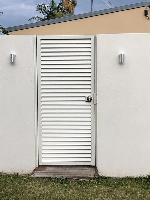 A White Door With Shutters on It is Sitting in Front of a White Wall — Sunshine Gates in Kunda Park, QLD
