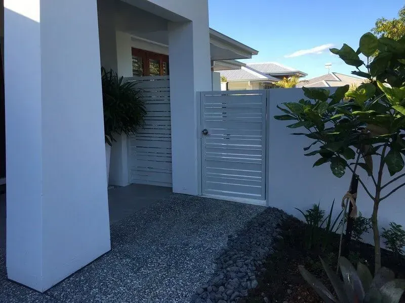 A White House With a White Gate in Front of It — Sunshine Gates in Kunda Park, QLD