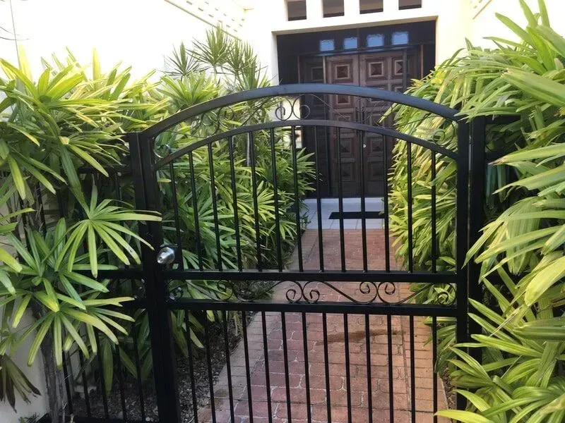 A Black Gate Leading to a House Surrounded by Plants — Sunshine Gates in Kunda Park, QLD