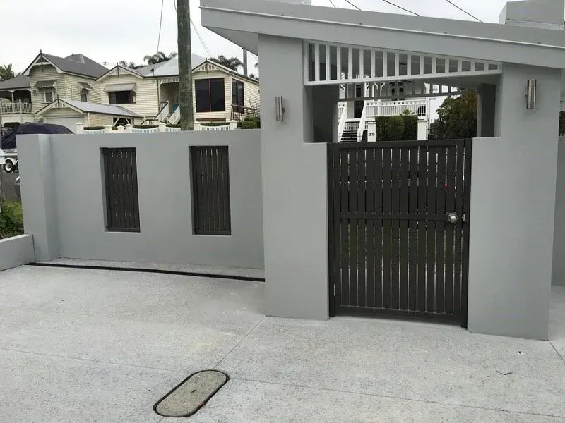 A White Fence With a Black Gate in Front of It — Sunshine Gates in Kunda Park, QLD