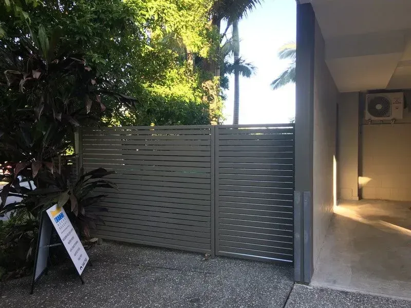 A Fence is Surrounding a Building With a Sign in Front of It — Sunshine Gates in Kunda Park, QLD