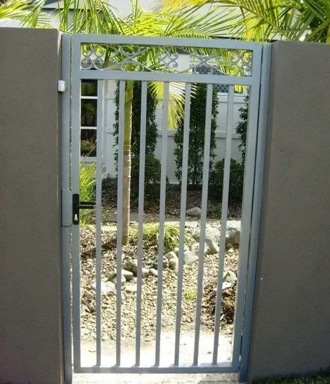 A Metal Gate Leading to a Garden With Palm Trees in the Background — Sunshine Gates in Kunda Park, QLD