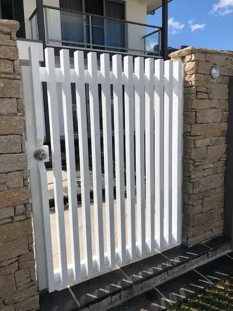 A White Gate is Between Two Brick Walls in Front of a House — Sunshine Gates in Kunda Park, QLD