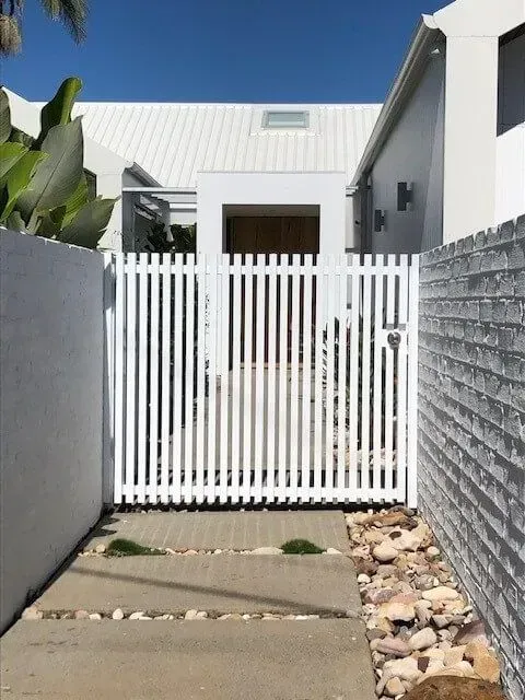 A White Fence Surrounds the Entrance to a House — Sunshine Gates in Kunda Park, QLD