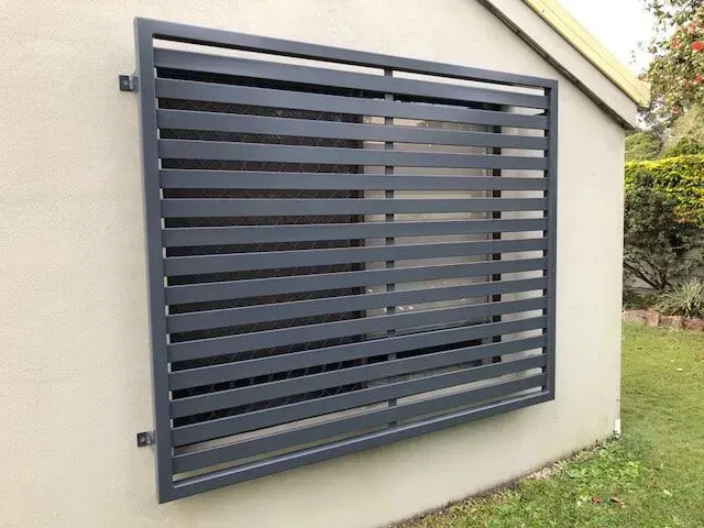 A Large Window With a Fence Around It on the Side of a Building — Sunshine Gates in Kunda Park, QLD
