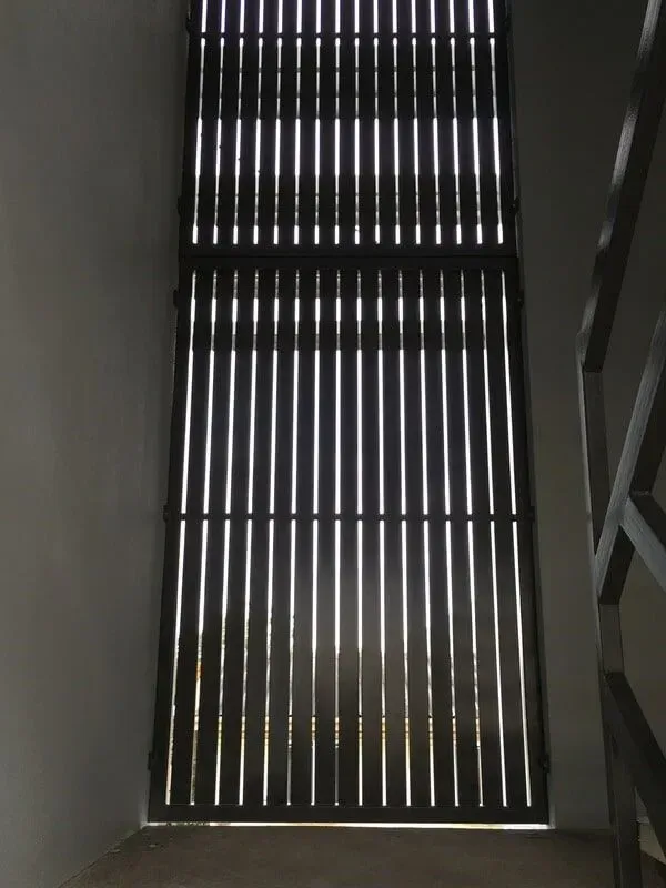 A Staircase With a Fence and a Window With a Light Coming Through It — Sunshine Gates in Kunda Park, QLD