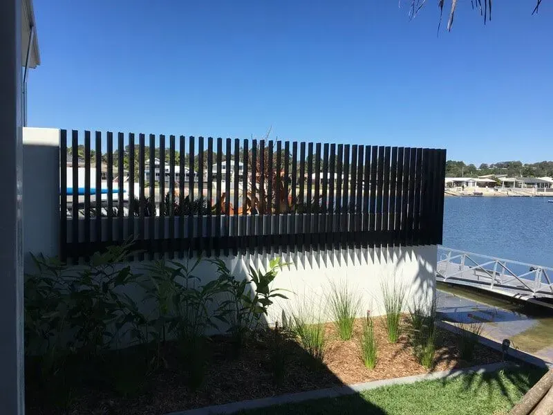 A Black Fence Surrounds a Yard With a View of a Body of Water — Sunshine Gates in Kunda Park, QLD