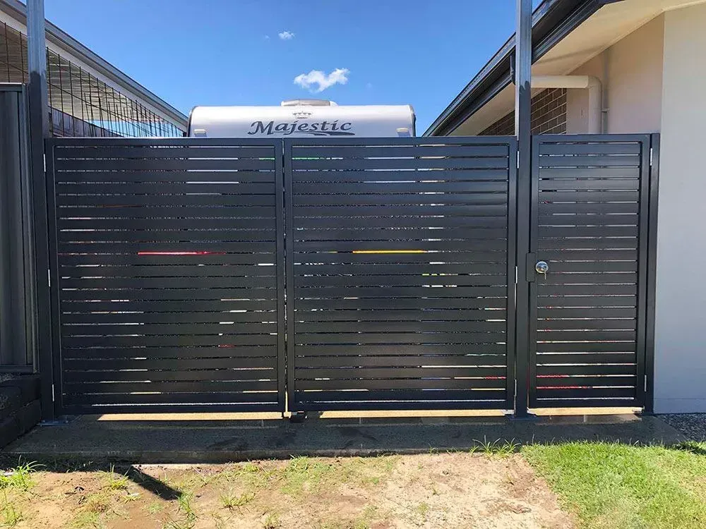 A Black Fence With a White Trailer in the Background — Sunshine Gates in Kunda Park, QLD