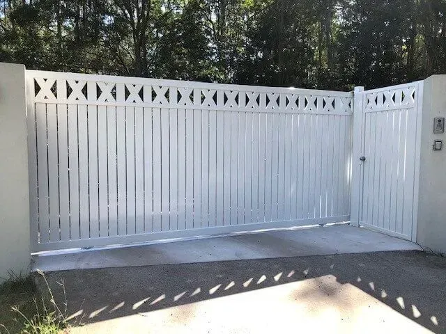 A White Gate is Open to a Driveway With Trees in the Background — Sunshine Gates in Kunda Park, QLD