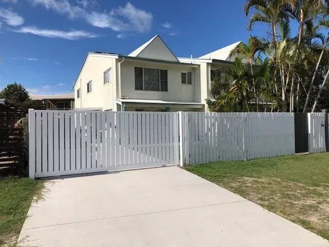 A White House With a White Fence in Front of It — Sunshine Gates in Kunda Park, QLD