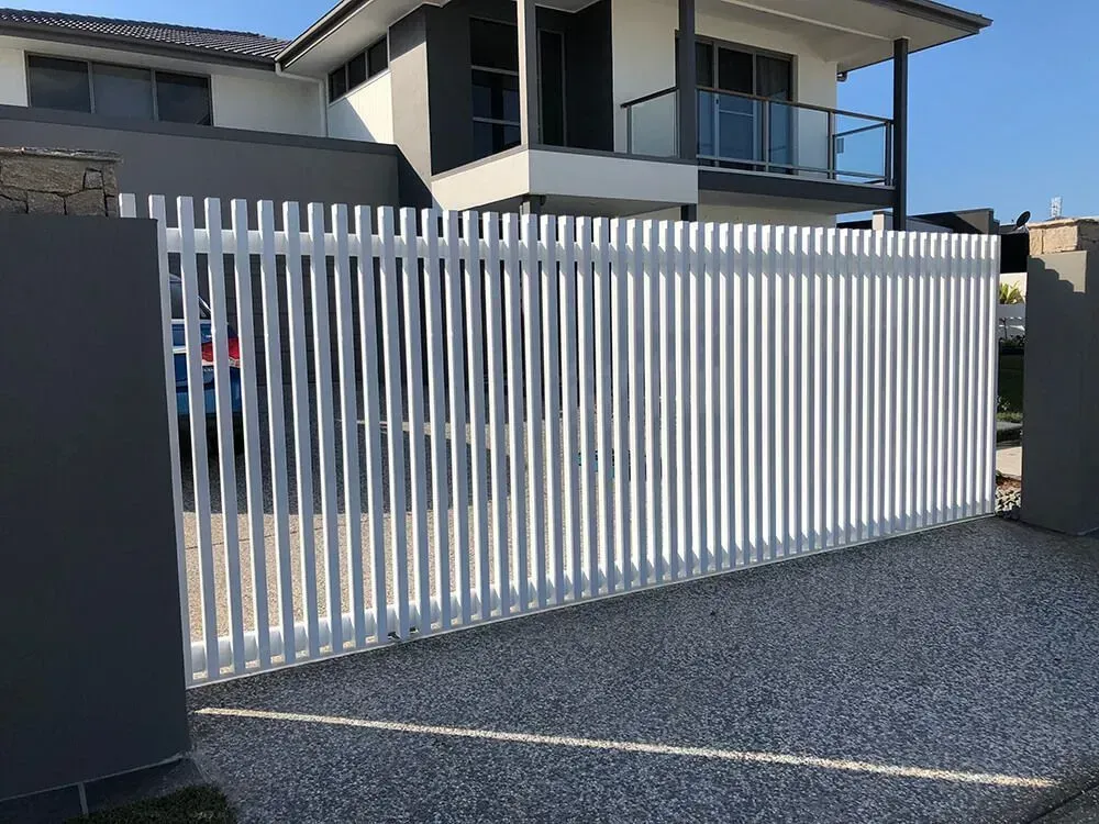 A White Fence is in Front of a Large House — Sunshine Gates in Kunda Park, QLD