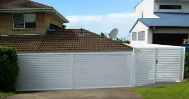 A White Garage Door is in Front of a House — Sunshine Gates in Kunda Park, QLD