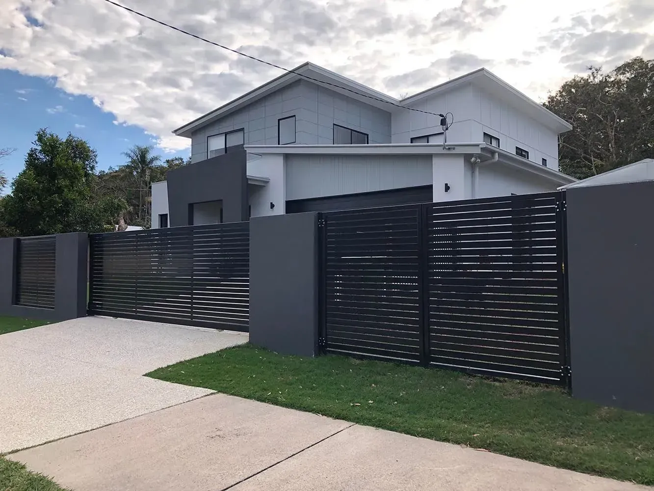 A Large White House With a Black Fence in Front of It — Sunshine Gates in Kunda Park, QLD