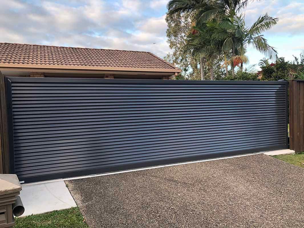 A Black Sliding Gate is Sitting in Front of a House — Sunshine Gates in Kunda Park, QLD