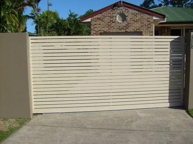 A White Sliding Gate is Open in Front of a House — Sunshine Gates in Kunda Park, QLD