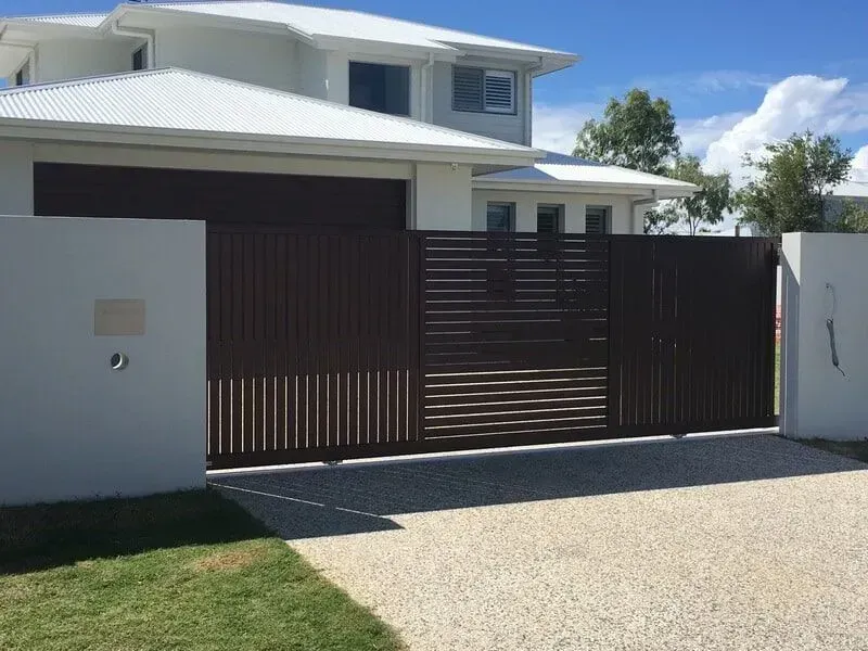 A Large White House With a Brown Sliding Gate in Front of It — Sunshine Gates in Kunda Park, QLD