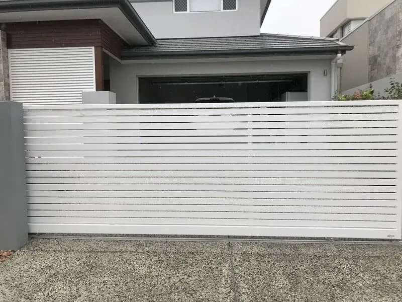 A White Sliding Gate is Sitting in Front of a House — Sunshine Gates in Kunda Park, QLD