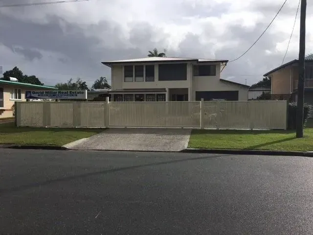 A House With a White Fence Surrounding It — Sunshine Gates in Kunda Park, QLD