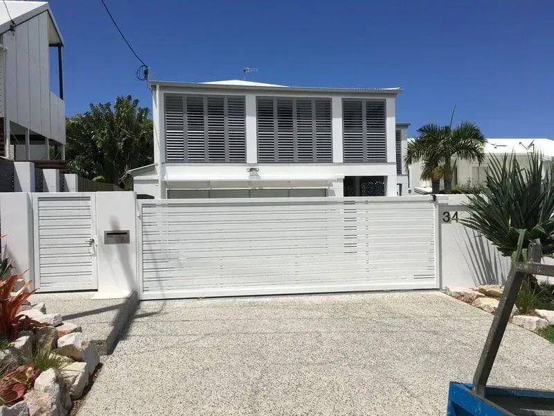 A White House With a Sliding Gate in Front of It — Sunshine Gates in Kunda Park, QLD