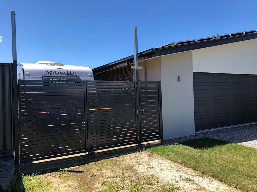 A Caravan is Parked in Front of a House Next to a Fence — Sunshine Gates in Kunda Park, QLD