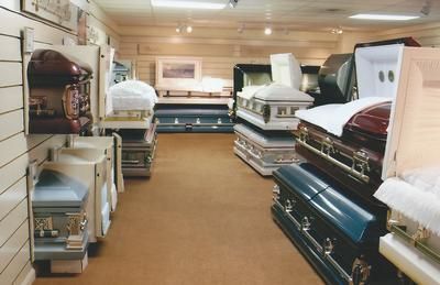 Mattress showroom with rows of stacked mattresses and bedding in a carpeted display room
