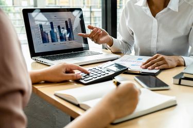 Two people reviewing financial data at a desk.