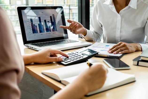 Two people reviewing financial data at a desk.