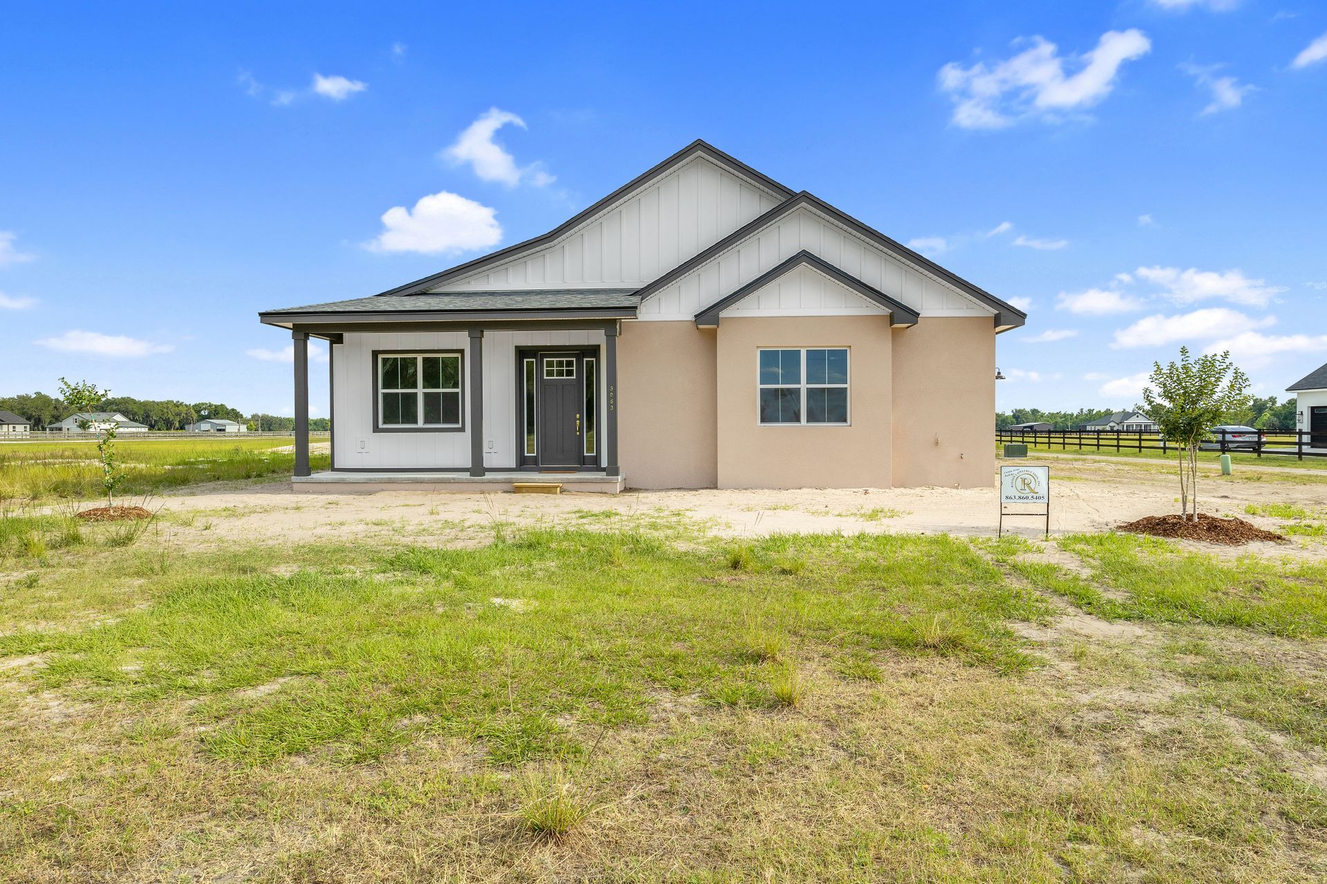 A small house is sitting in the middle of a grassy field.