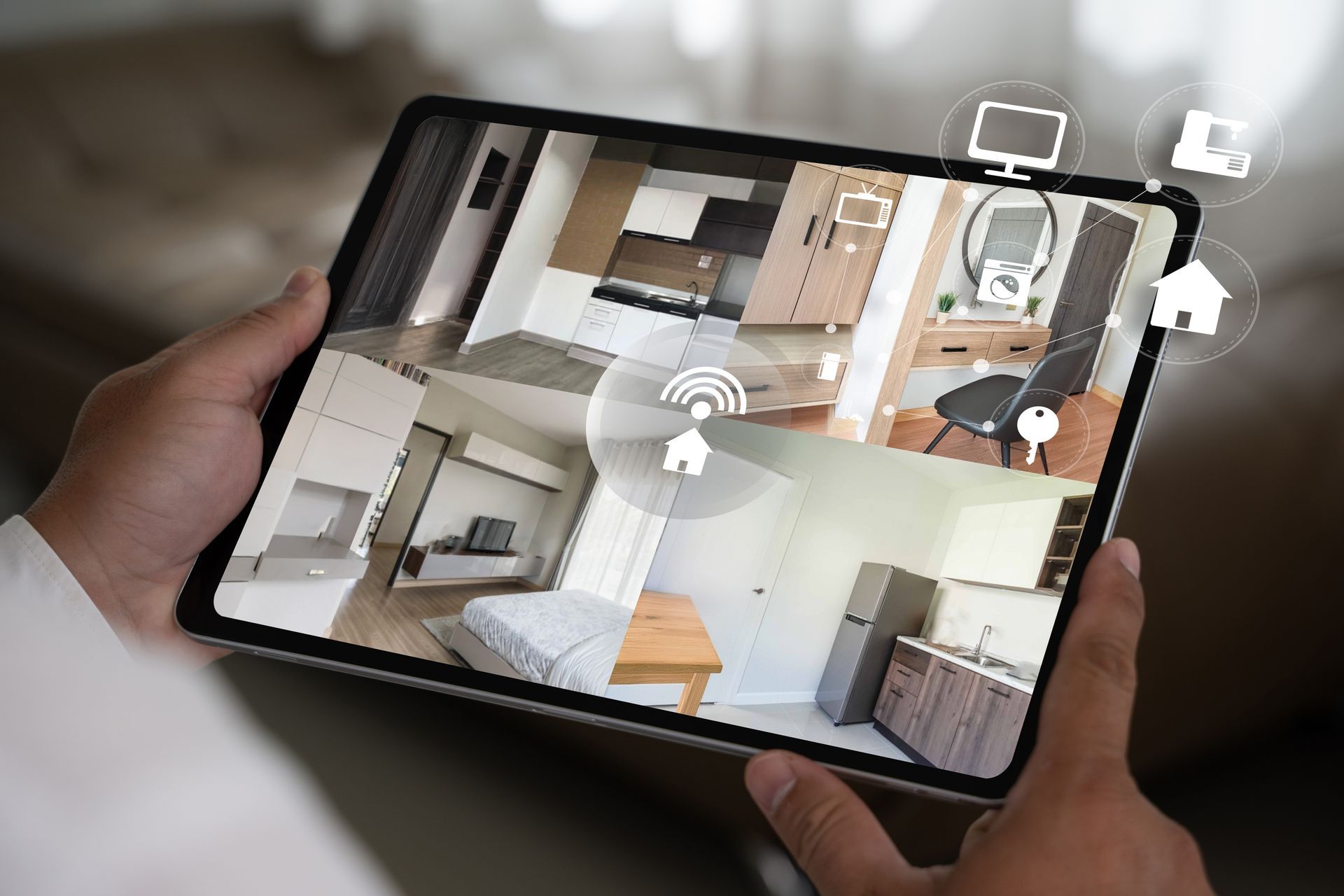 Hands holding a tablet showing a home floor plan and room layout app