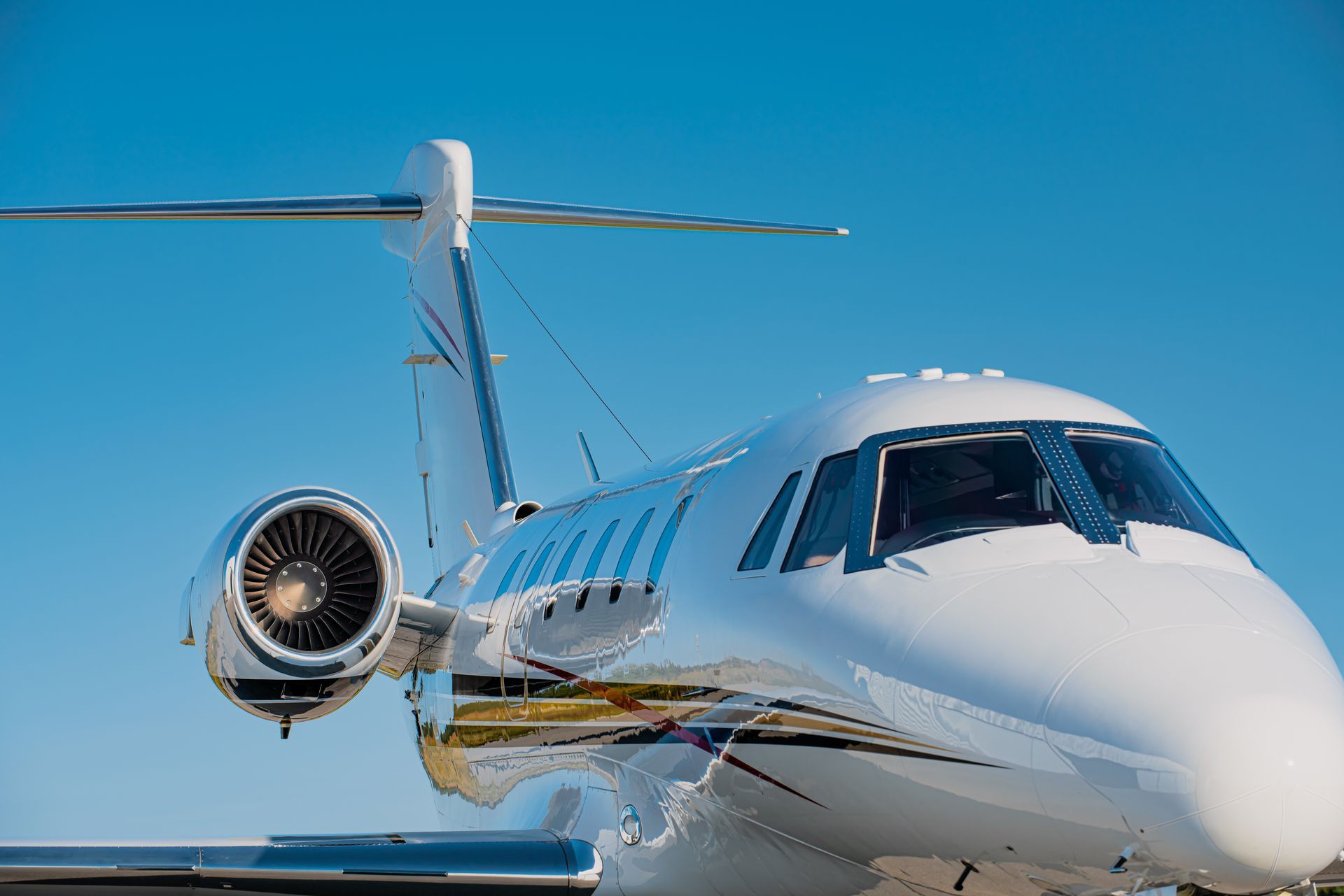White private jet on runway against clear blue sky